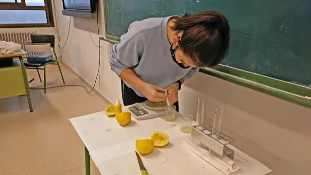 Una alumna del IES Valle del Ebro realiza experimentos para comprobar si el jugo del cítrico pierde sus vitaminas una vez exprimido