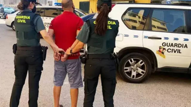 Dos agentes de la Guardia Civil junto al detenido en un supermercado de Menorca.