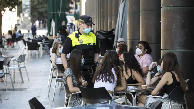 Un policía obliga del uso obligatorio de la mascarilla en Zaragoza, en una imagen de archivo.