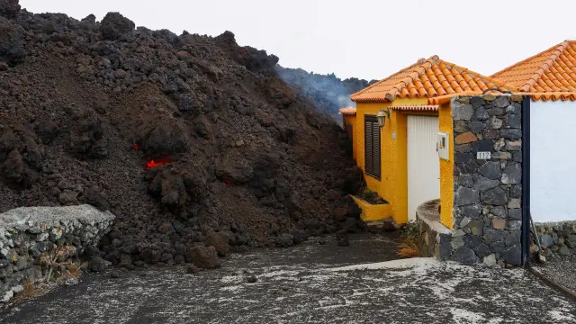 Lava reaches a house following the eruption of a volcano in Spain