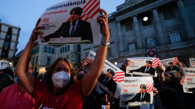 Una mujer sostiene un cartel de apoyo a Puigdemont en una concentración este viernes en Barcelona.