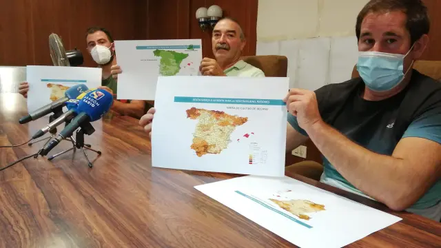 De izquierda a derecha, César Izquierdo, Ricardo Plumed y Francisco Ramo, de la plataforma Agrigate, muestran el mapa de reparto de ayudas. En color claro, las provincias cuyos agricultores percibirán menos dinero.