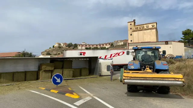 Un camión que transportaba pacas de paja ha volcado esta mañana al tomar la glorieta de acceso a Berbegal