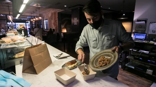 Un trabajador del restaurante La Bocca envasaba ayer los excedentes de una paella.