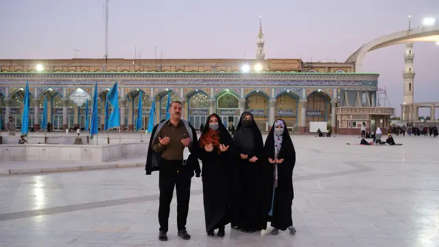 Una familia reza delante de la mezquita de Yamkarán