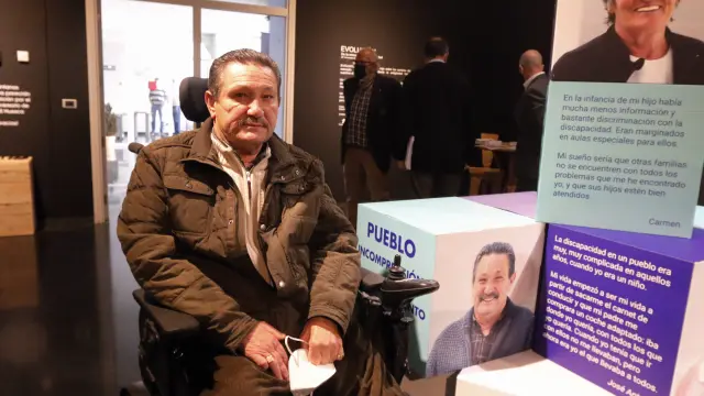José Antonio Oliva junto a un totem de la exposición de Cadis con su fotografía y testimonio.