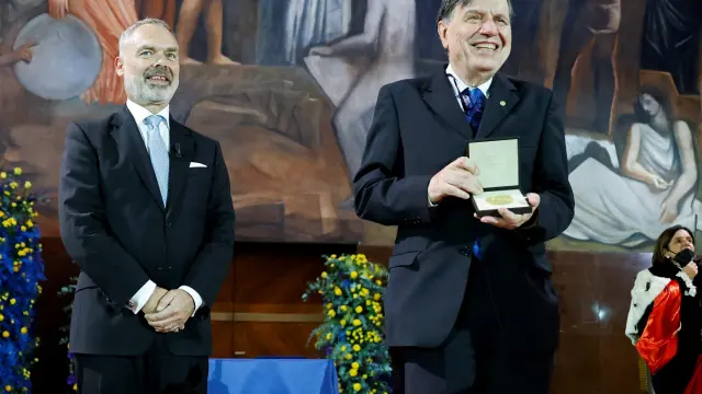 Parisi muestra su premio Nobel en presencia del embajador sueco en Italia, Jan Björklund.