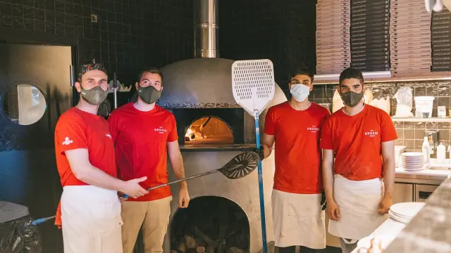 Cuatro pizzaiolos, junto al horno de la pizzería Grosso Napoletano en Zaragoza.