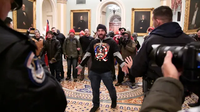 A supporter of President Donald Trump confronts police as Trump supporters demonstrate on the second floor of the U.S. Capitol near the entrance to the Senate after breaching security defenses, in Washington, U.S., January 6, 2021.         REUTERS/Mike Theiler[[[REUTERS VOCENTO]]]