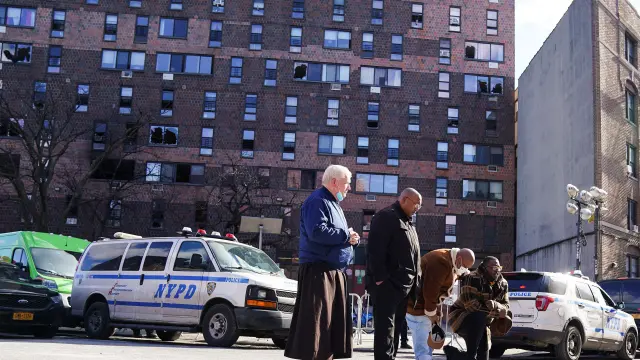 Varias personas rezan delante del edificio siniestrado, en el barrio del Bronx de Nueva York.