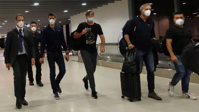 Djokovic, acompañado de su equipo, en el aeropuerto de Melbourne.