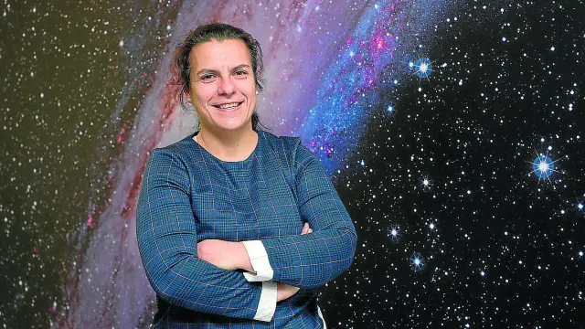 Maribel Aguilar, coordinadora de Galáctica, delante de una imagen de la galaxia Andrómeda.
