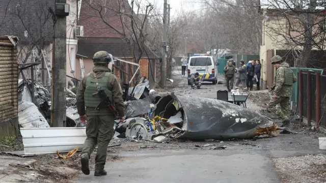 Soldados ucranianos observan los restos de un avión militar que fue derribado durante la noche en Kiev