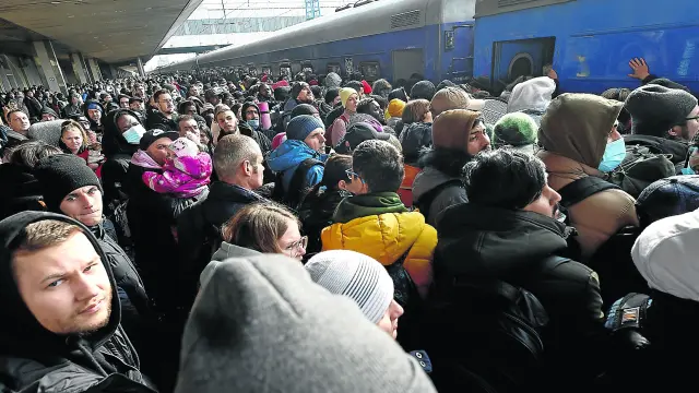 Cientos de personas intentan subir a un tren que los saque de Kiev