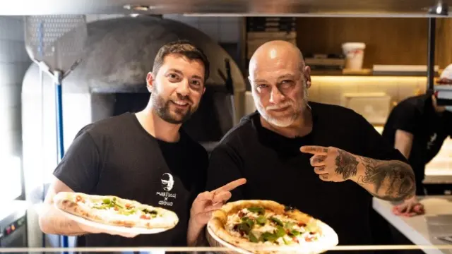 Francesco Martucci (derecha) sostiene una 'Mani de Martucci', la pizza efímera que ha hecho en colaboración con Grosso Napoletano.