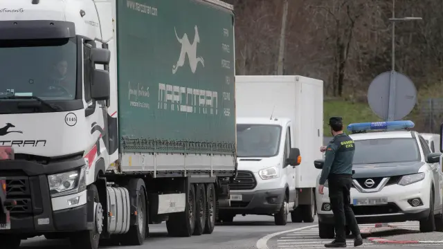 Un agente de la Guardia Civil dirige el tráfico de camiones en Lugo, durante el cuarto día de paros en el sector de los transportes.