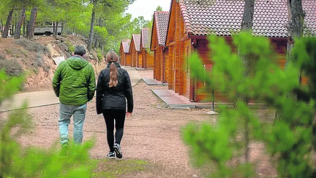 Dos personas pasean por el Camping Lago Resort de Nuévalos.