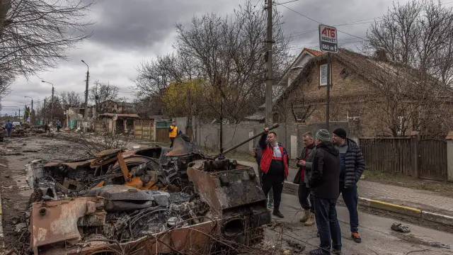 Bucha (Ukraine), 06/04/2022.- Vladyslava Liubarets (C), a Bucha resident, walks with her family past destroyed Russian military machinery, to meet her sister whom she did not see since the beginning of the Russian invasion, in Bucha, the town which was retaken by the Ukrainian army, northwest of Kyiv, Ukraine, 06 April 2022. Hundreds of tortured and killed civilians have been found in Bucha and other parts of the Kyiv region after the Russian army retreated from those areas. Russian troops entered Ukraine on 24 February resulting in fighting and destruction in the country, and triggering a series of severe economic sanctions on Russia by Western countries. (Rusia, Ucrania) EFE/EPA/ROMAN PILIPEY UKRAINE RUSSIA CONFLICT