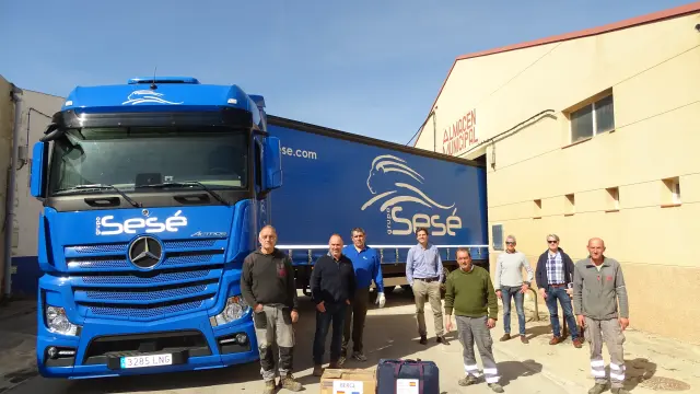 El camión que ha salido este jueves desde Alcorisa con destino a un centro logístico de Polonia junto al personal que de la empresa Sesé y el alcalde de la localidad, Miguel Iranzo, segundo por la izquierda.