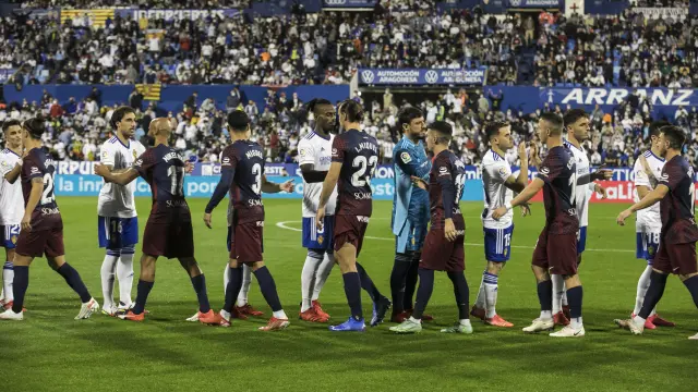 Los jugadores del RealZaragoza y Huesca se saludan antes del partido de la primera vuelta en La Romareda.
