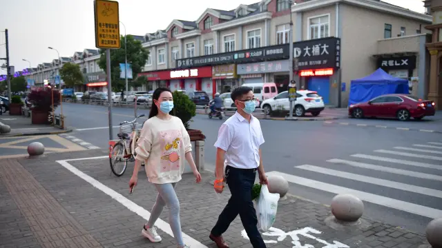 Residents walk on a street as Shanghai eases lockdown in some areas