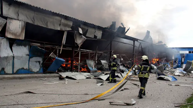 Firefighters work to to extinguish a fire that broke out in a steel warehouse following a military strike, amid Russia's invasion of Ukraine, in Kharkiv, Ukraine, April 23, 2022. REUTERS/Oleksandr Lapshyn UKRAINE-CRISIS/