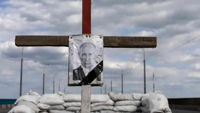 A portrait of Russian President Vladimir Putin in a cross depicting his tomb is seen at a checkpoint outside Dnipro