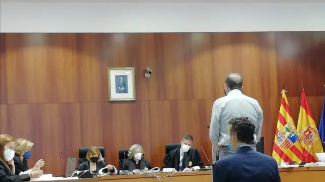 El acusado, de pie con camisa blanca, durante el juicio celebrado este lunes en la Audiencia de Zaragoza.