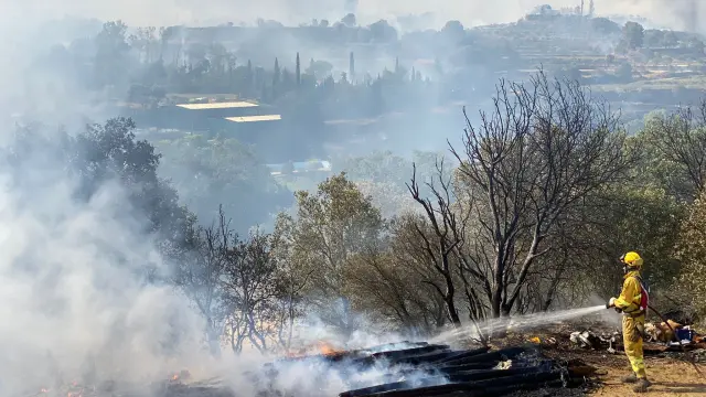 Trabajos de extinción en el incendio que ha comenzado al mediodía de este sábado junto a la A-2202, de Barbastro a Cregenzán
