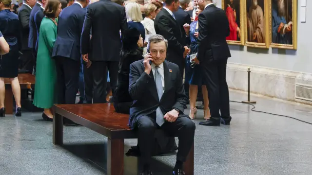 Mario Draghi hablando por teléfono apartado del resto de líderes de la OTAN en el Museo del Prado