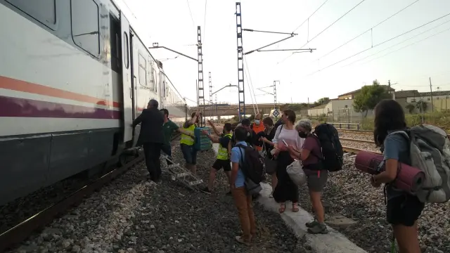 Los viajeros descienden del tren averiado este martes por la tarde a las afueras de Tardienta.