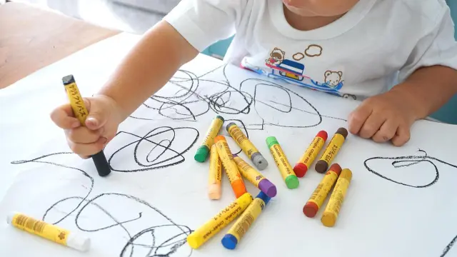 Imagen de archivo de un niño pintando con ceras