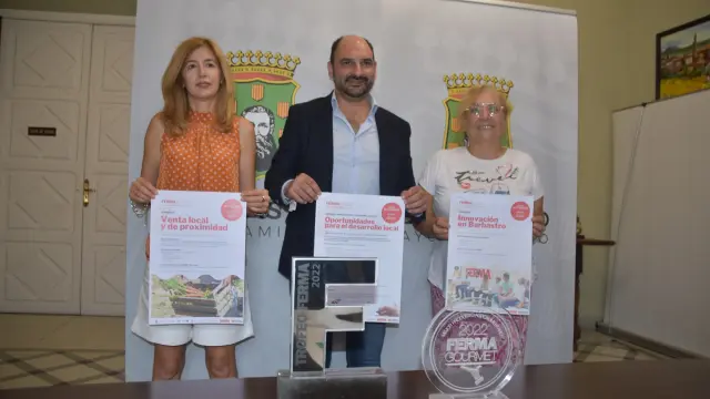 La concejal Belinda Pallás, el alcalde Fernando Torres y Asun Berroy de AMEPHU con el cartel de la triple jornada de FERMA Innova.