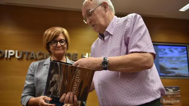 La diputada Maribel de Pablo y el fotógrafo Fernando Bierge examinan el libro sobre Monegros.