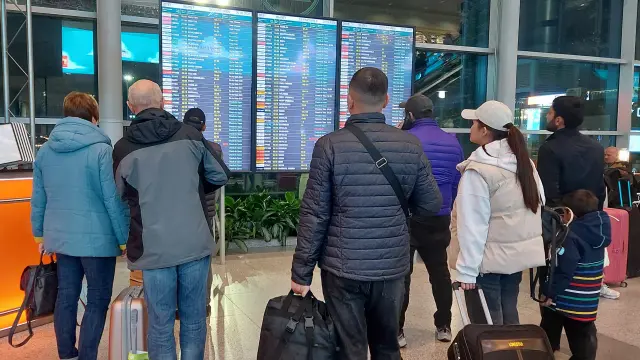 Varias personas comprueban el estado de sus vuelos en las pantallas del aeropuerto de Domodédovo en Moscú, Rusia.