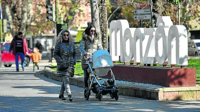 Dos mujeres pasean con un carrito de bebé por Monzón.
