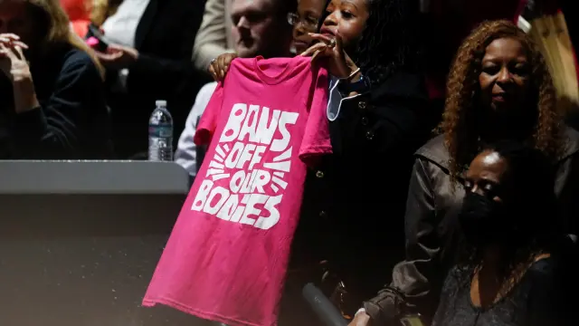 Una mujer muestra una camiseta a favor del derecho al aborto durante una comparecencia de Kamala Harris.
