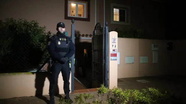 Un policía custodia el edificio donde se han hallado los cadáveres de la pareja en La Línea, Cádiz.