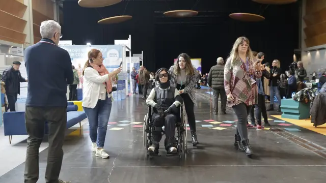 Eva Caballero va en silla de ruedas con los elementos que le permiten meterse en la piel de una persona mayor con limitaciones físicas y sensoriales