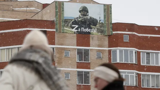 Una mujer pasa por delante de un cartel donde se lee 'Z: hasta la victoria' en una zona residencial de Moscú