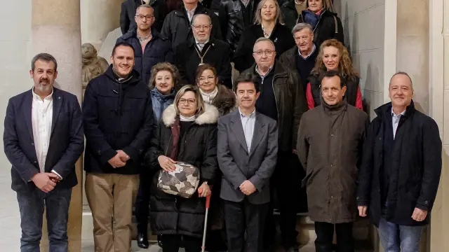El alcalde de Huesca y los representantes de las cofradías de Huesca y Segovia en el patio de entrada del Ayuntamiento oscense.