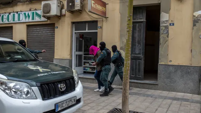 Dos agentes de la Guardia Civil se llevan detenida a una persona en Melilla.