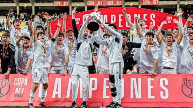 Cucalón, a la izquierda de la copa, levanta el trofeo conquistado por el Real Madrid.