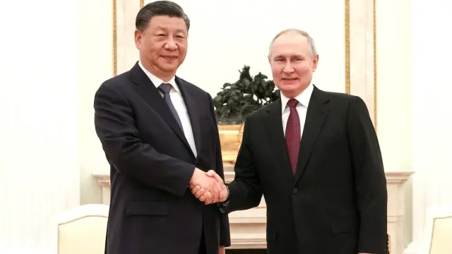 Vladimir Putin y Xi Jinping se saludan momentos antes de la reunión privada que han mantenido este lunes en Moscú.