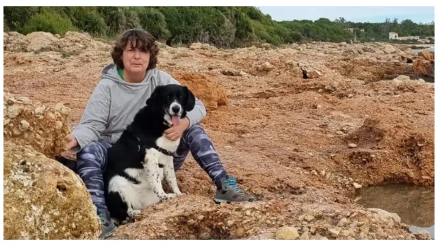 Pilar Fuertes, paciente de cáncer de colon, en la playa con su perro.