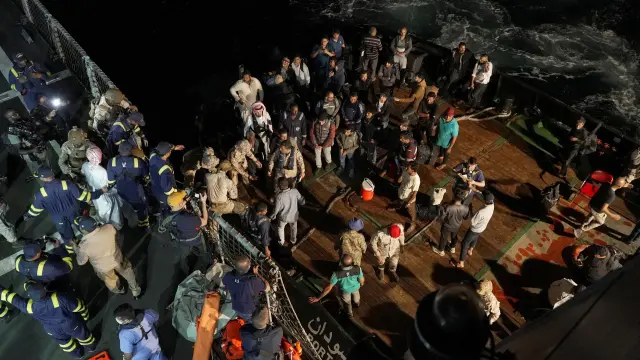 Militares saudíes ayudan a subir a un barco a un grupo de civiles que son evacuados en Puerto Sudán