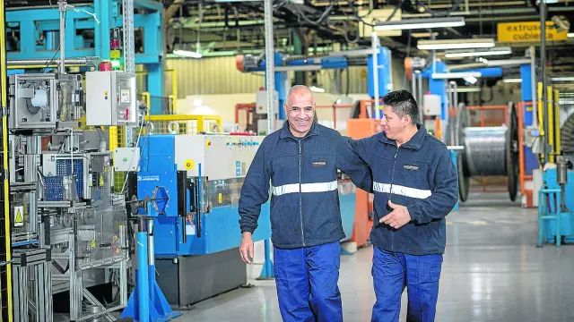 Un par de trabajadores en las instalaciones de Cablescom en el polígono de Malpica (Zaragoza)