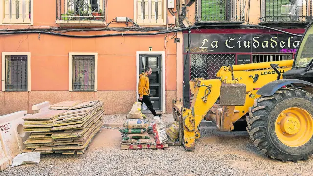 Un vecino camina por la acera frente a material de obra en la calle de Concepción Arenal de Zaragoza