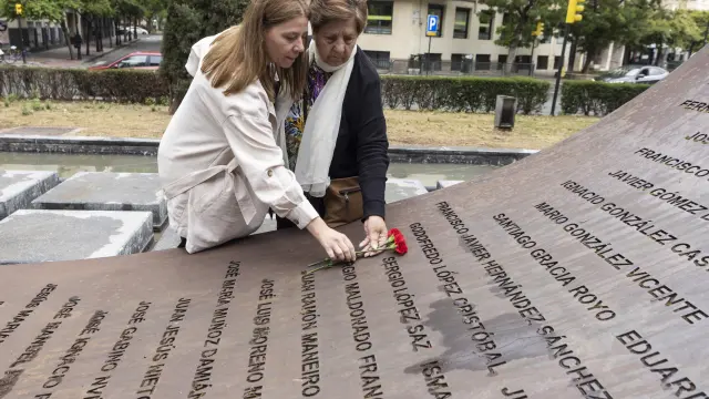 María Saz y su hija Sandra colocan dos claveles del ramo donde está el nombre de su familiar, el brigada Sergio López Saz, en el monumento del paseo Constitución.