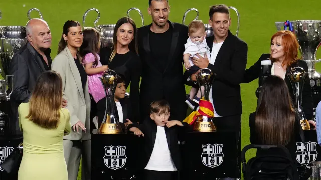 El futbolista del FC Barcelona, Sergio Busquets (c), acompañado por su familia durante la despedida ofrecida hoy miércoles al centrocampista blaugrana en el estadio del Camp Nou, en Barcelona.